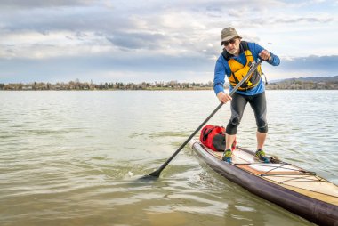 sefer paddleboard göl kenarında ayakta