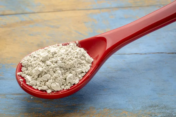 Élelmiszer-minőségű diatomaceous föld kiegészítése egy kanál — Stock Fotó