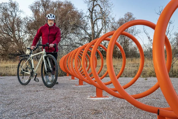Rowerzysta zbliża się kolorowy helix stojak rowerowy — Zdjęcie stockowe