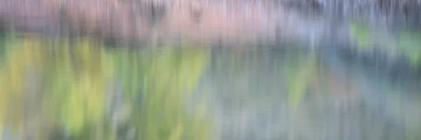 Abstracte waterreflectie van zandstenen klif en bomen — Stockfoto