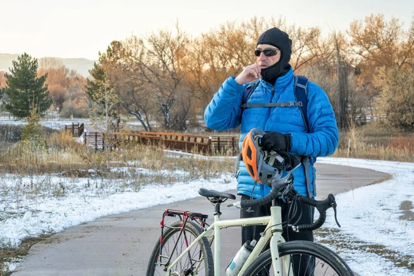 Kışın bisiklet sürmek için kar maskesi ve kask takıyorlar.