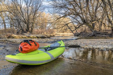 whitewater inflatable kayak on a river shore clipart