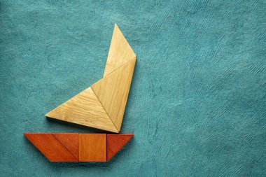turkuaz kağıt üzerinde tangram yelkenli