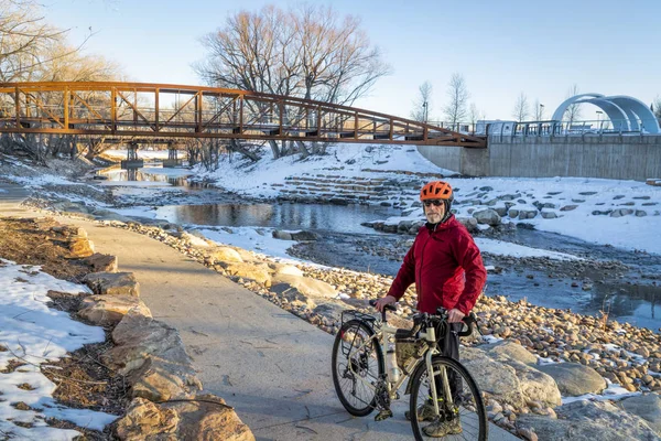 Старший велогонщик едет на велосипеде в зимний закат — стоковое фото