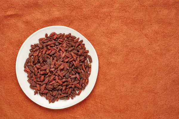 Dried goji berries on a white plate — Stock Photo, Image
