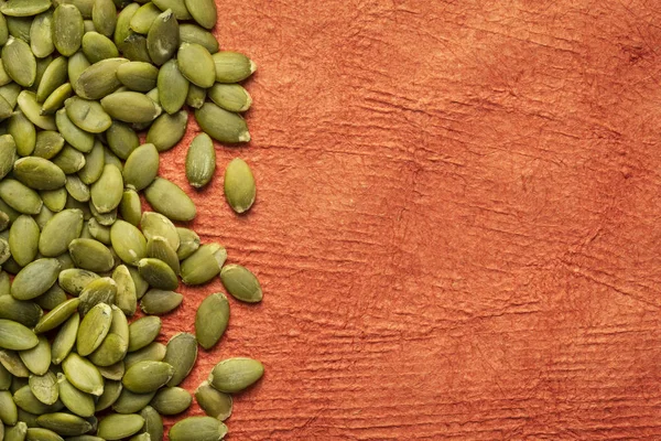 Surowe nasiona dyni na papierze teksturowanym — Zdjęcie stockowe
