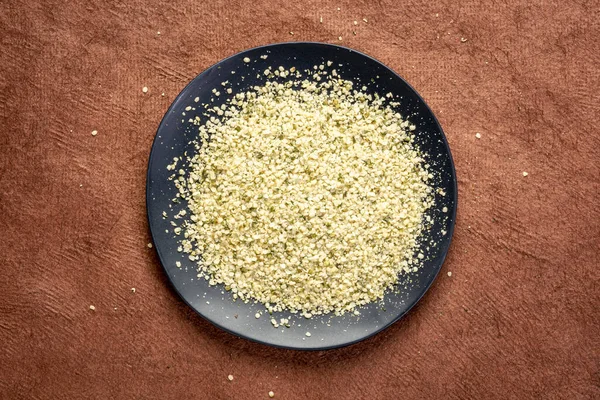 Hemp seed hearts on a black plate — Stock Photo, Image