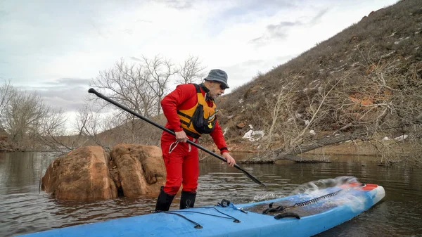 Senior maschio stand up paddler in una muta asciutta — Foto Stock