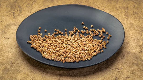 Kasha di grano saraceno su un piatto nero — Foto Stock