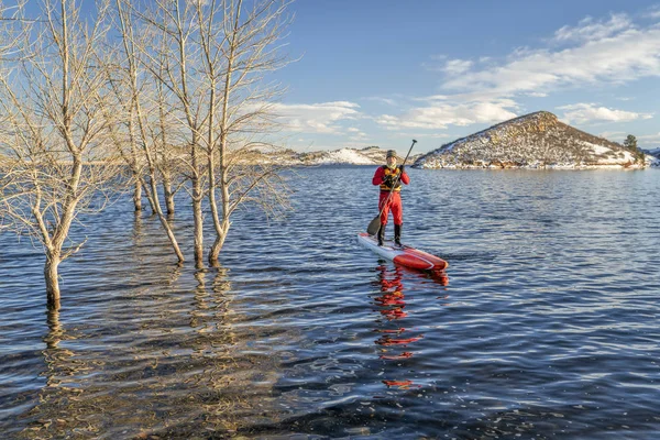 Actif senior est pagayer stand up paddlenboard en hiver — Photo