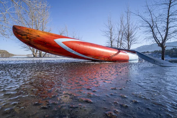 部分的に凍結した湖の上にパドルボードを立つ コロラド州北部のHorsetooth貯水池 冬のパドリング フィットネス トレーニングコンセプト — ストック写真