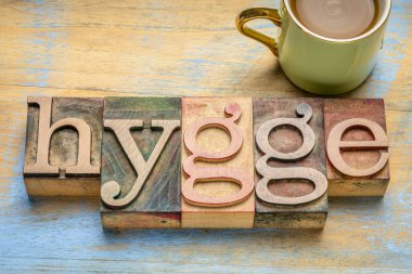 Kaliteli harf harfleriyle süslü tahta bloklar, bir fincan kahveyle grunge odununa karşı Danimarka konforlu ve rahat yaşam tarzı konsepti.