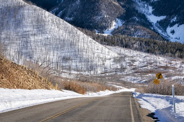 scenic windy mountain road in winter scenery - La Sal Mountain Loop near Moab Utah, travel concept