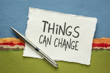 Bazı şeyler değişebilir - iyimser ilham verici hatırlatma, renkli soyut manzaraya karşı el yapımı bir kağıt üzerinde el yazısı