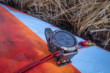 Fort Collins, CO, ABD - 10 Nisan 2020: Garmin fenix Pro 6X güneş sporu saati eğitim saati yüzlü, ayakta duran bir kürek tahtasında..