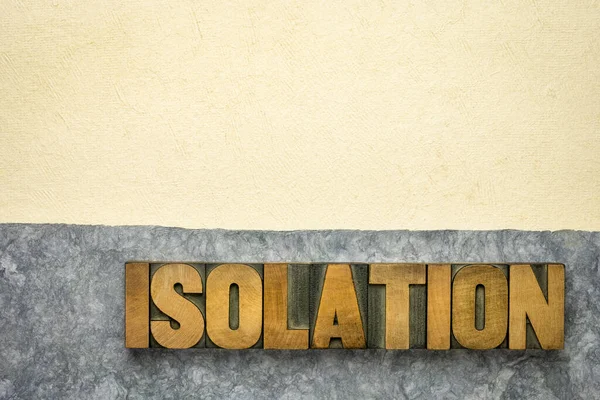 isolation word abstract in vintage letterpress wood type and handmade bark paper, loneliness, social distancing or quarantine during coronavirus covid-19 pandemic concept