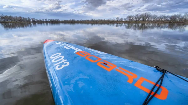 フォートコリンズ アメリカ 2020年4月27日 コロラド州北部の早春の風景の中に静かな湖の上にレーススタンドアップパドルボード 2016すべてのスター汎用性の高いレースデザインスターボード — ストック写真