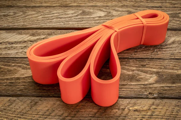 resistance exercise band for fitness and rehabilitation against wooden background