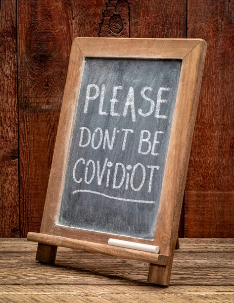 Covidiotを使用しないでください コロナウイルスCovid 19パンデミック ホワイトチョーク黒板の看板中に公衆衛生や安全性や社会的距離に関する警告を無視する人 — ストック写真