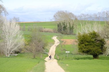 Mollet del Valles, Katalonya / İspanya - 5 Nisan 2018: İspanya'nın Katalonya bölgesindeki Barselona eyaletindemollet del Valles'te yeşil alanlar arasındaki ufka giden ülke yolu