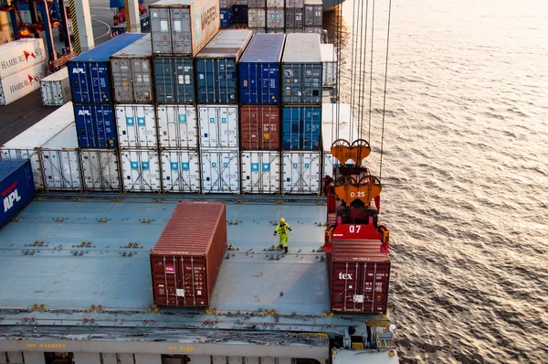 Arbeiter hilft beim Hochladen von Containern am Dock — Stockfoto