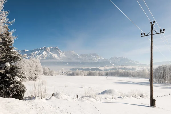 Austrian Winter Wonderland with mountains, a power pole, fresh snow and haze — Stock Photo, Image