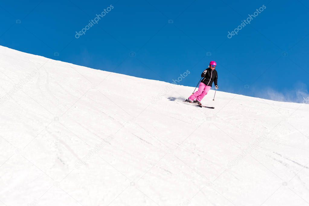 Female skier in fresh powder snow and blue sky