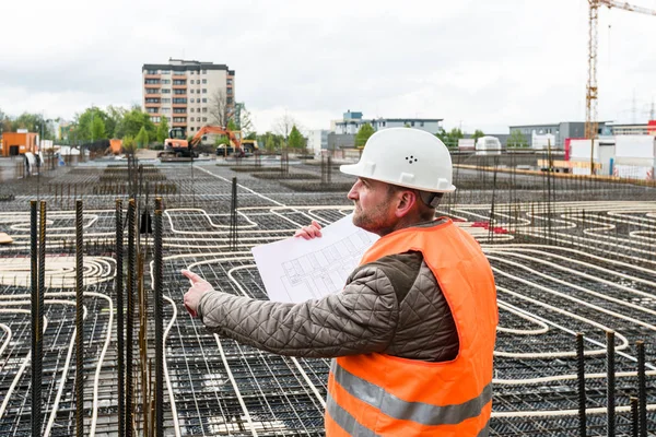 Supervisor de construcción con plan en el sitio — Foto de Stock