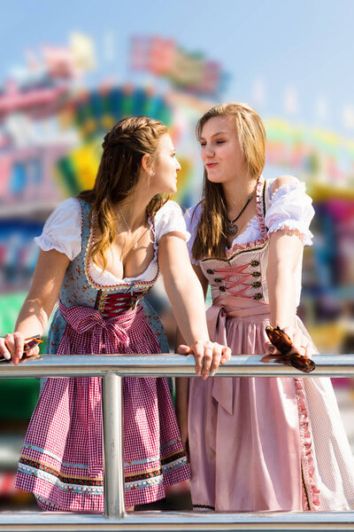 Attractive young women at German funfair Oktoberfest with traditional dirndl dresses
