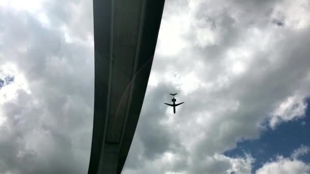 Vliegtuig vliegen langs enorme betonnen brug — Stockvideo
