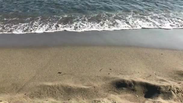 Волны мягко бьются на тихом песчаном пляже — стоковое видео