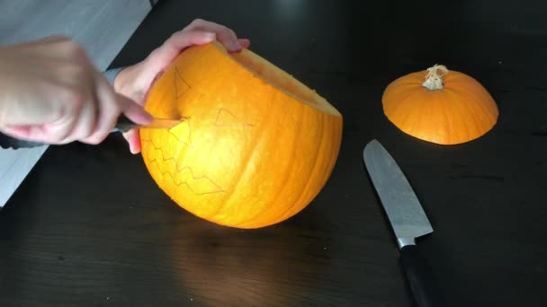 Las manos femeninas están tallando una calabaza de Halloween — Vídeo de stock