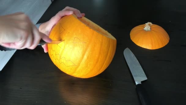 Le mani femminili stanno intagliando una zucca di Halloween — Video Stock