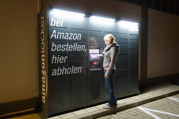 A woman is using an Amazon Locker station located next to an Aldi supermarket. — Stock Photo, Image