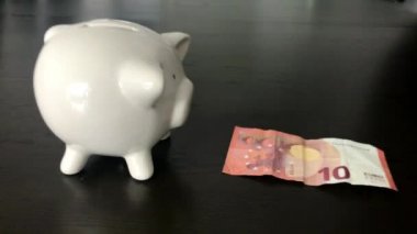 Bir on Euro banknot bir kumbara koyarak kadın