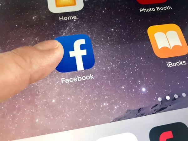 Macro immagine di un dito che sta per fare clic sull'icona di Facebook su uno schermo iPad — Foto Stock