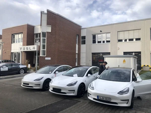 Mensen halen hun nieuwe Tesla-voertuigen - voornamelijk Model 3 - op bij het Bezorgingscentrum van München. — Stockfoto