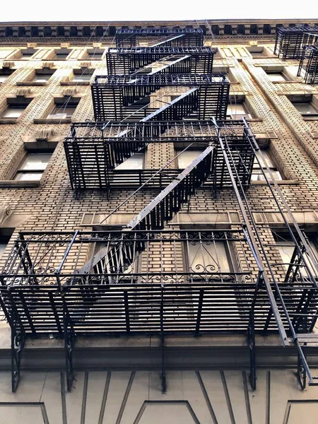 Typical New York apartment building with steel fire escape ladders