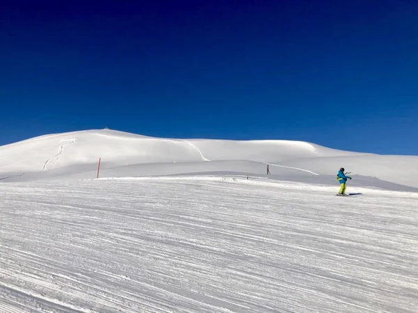 Pente enneigée dans les montagnes avec ciel bleu — Photo