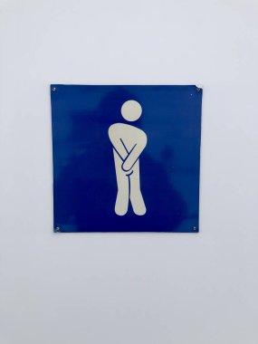 Dizleri birbirine bastırılmış bir adamın komik tuvalet işareti.