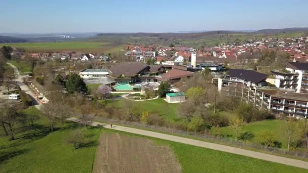 Vol par drone vers le bain thermal vide de Beuren sur les Alpes souabes, Allemagne par une journée ensoleillée — Video