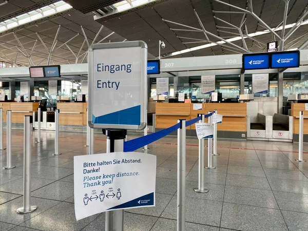 Surto de coronavírus: balcões de check-in vazios com lembretes de segurança de Corona no terminal do aeroporto devido a pandemia de coronavírus e companhias aéreas suspenderam a maioria de seus voos em Stuttgart, Alemanha . — Fotografia de Stock
