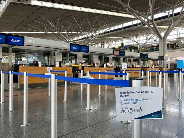 Surto de coronavírus: balcões de check-in vazios com lembretes de segurança de Corona no terminal do aeroporto devido a pandemia de coronavírus e companhias aéreas suspenderam a maioria de seus voos em Stuttgart, Alemanha . — Fotografia de Stock