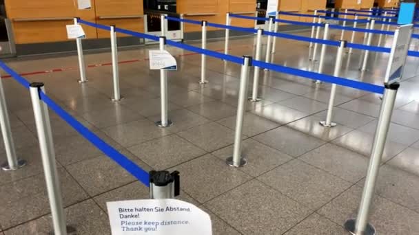 Coronavirus-Ausbruch: Leere Check-in-Schalter mit Corona-Sicherheitshinweisen im Terminal des Flughafens wegen Coronavirus-Pandemie und Fluggesellschaften setzen die meisten Flüge in Stuttgart aus. — Stockvideo