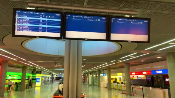 Epidemia koronawirusa: Prawie puste tablice przylotów i porzucone wypożyczalnie samochodów na lotnisku z powodu pandemii koronawirusów i linii lotniczych zawiesiły większość lotów do Stuttgartu — Wideo stockowe