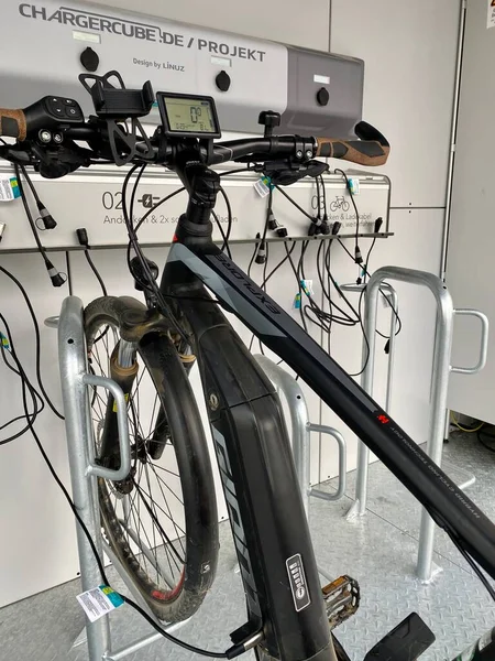 Modern electric bike charging station. Green technology concept by manufacturer ChargingCube, a solar powered container with several cables providing free of charge recharfing for e-bikes at the — Stock Photo, Image