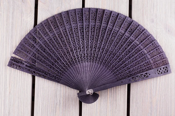 Black fan over wooden table