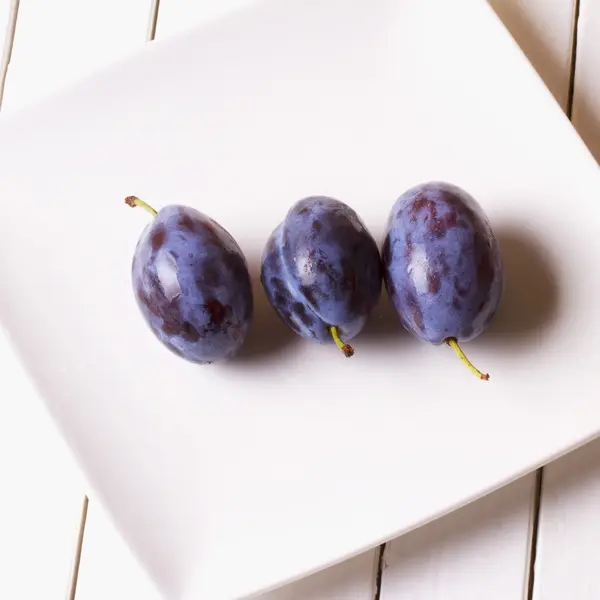 Prunes over a white plate — Stockfoto