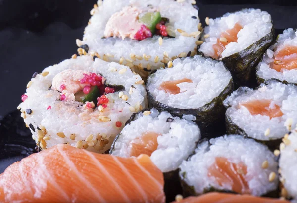 Sushi z kilku typów na czarnej płycie — Zdjęcie stockowe