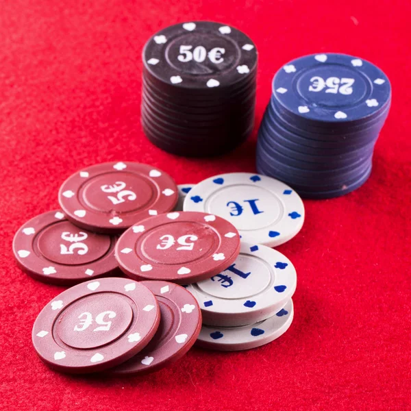 Jetons de poker sur tissu rouge — Photo